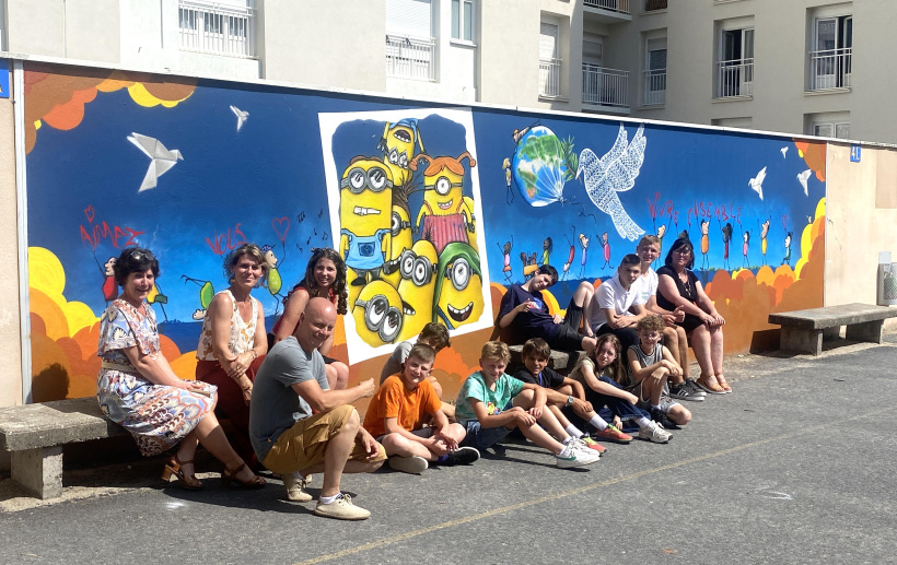 Les élèves, la direction du collège Jules Vallès et Dege, devant le mur de la Paix. 