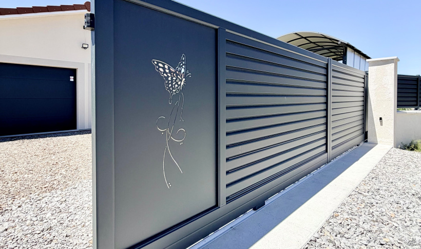 Un second motif, représentant un papillon, vient compléter la personnalisation de ce portail coulissant en aluminium.