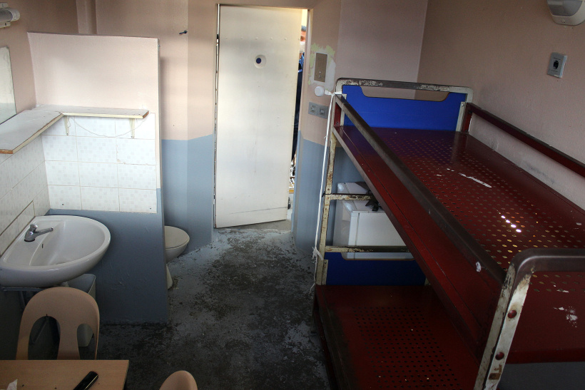 Les détenus sont entassés à 3 dans les cellules, certains allongés sur un matelas au sol.